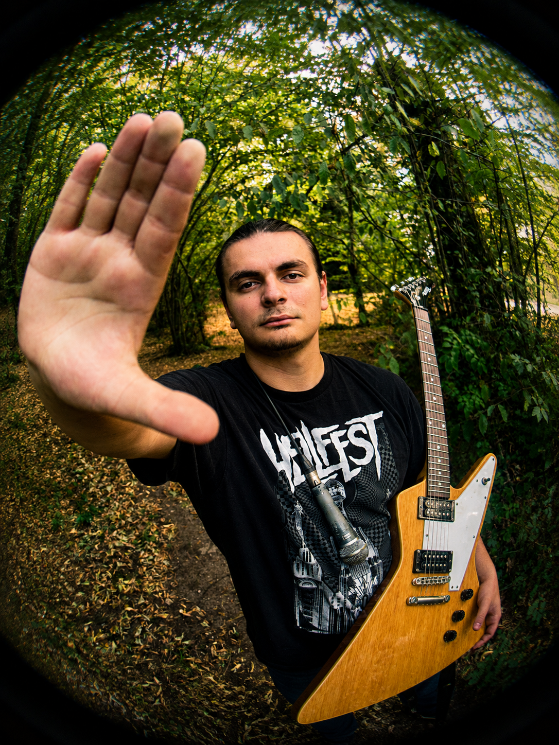 Yanis, vocals and guitar of SelfMind, holding his guitar in the woods
